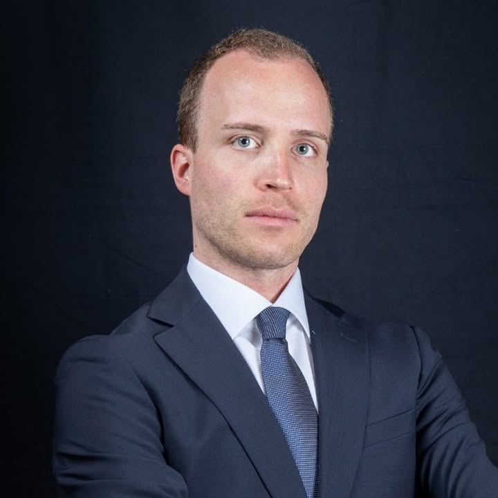 Ritratto di Stefano Bini in giacca blu, camicia bianca e cravatta